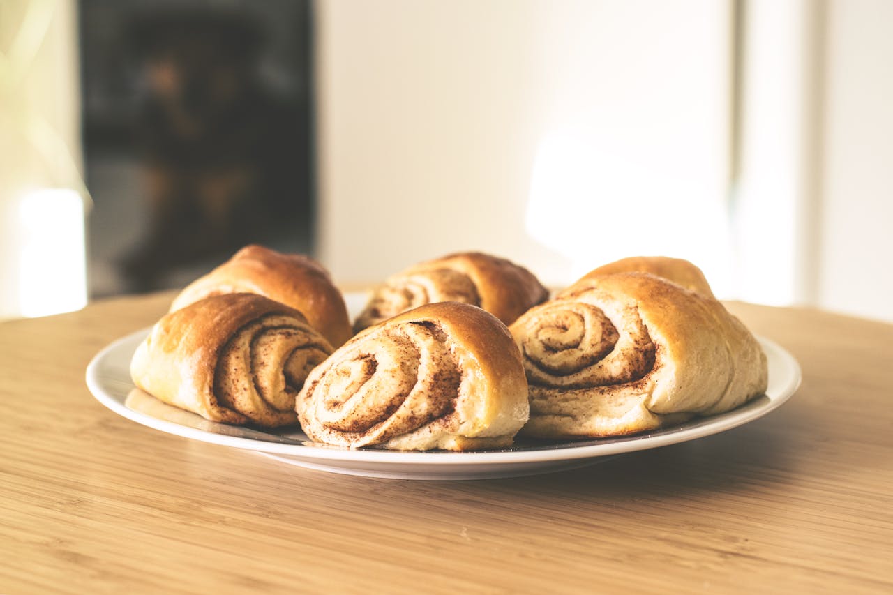 Warm and inviting cinnamon rolls on a white plate, perfect for a sweet treat.